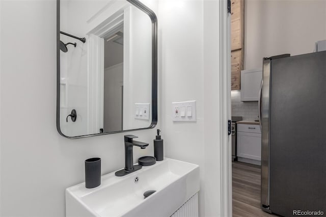 bathroom featuring sink, wood-type flooring, and backsplash