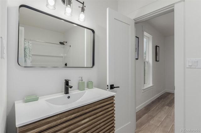 bathroom with vanity, walk in shower, and wood-type flooring