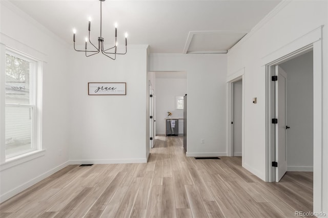 unfurnished dining area featuring light hardwood / wood-style flooring, ornamental molding, and plenty of natural light