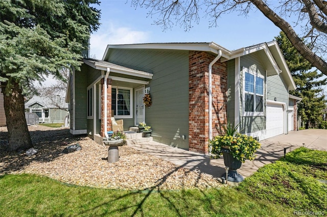 view of front of home featuring driveway, brick siding, and an attached garage