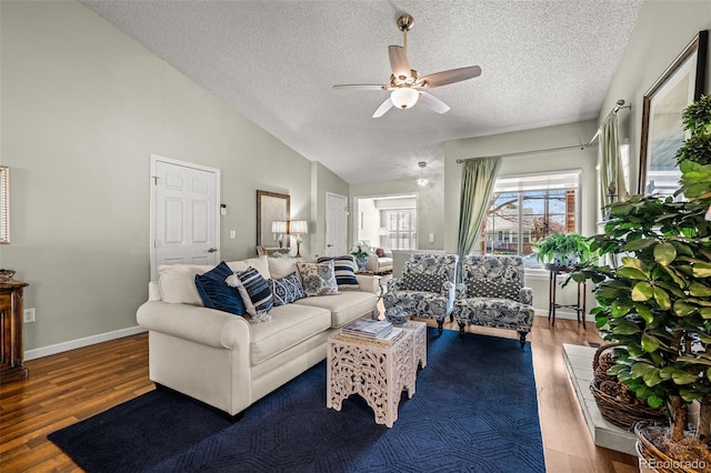 living area featuring a textured ceiling, a ceiling fan, wood finished floors, lofted ceiling, and baseboards