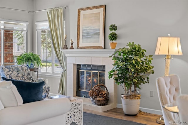 sitting room featuring wood finished floors, baseboards, and a tile fireplace