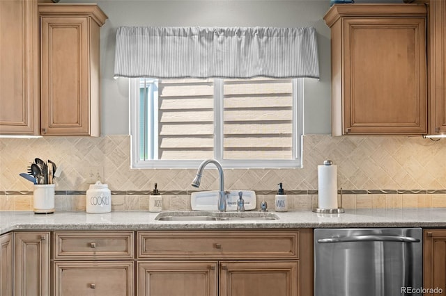 kitchen with stainless steel dishwasher, a sink, tasteful backsplash, and brown cabinetry