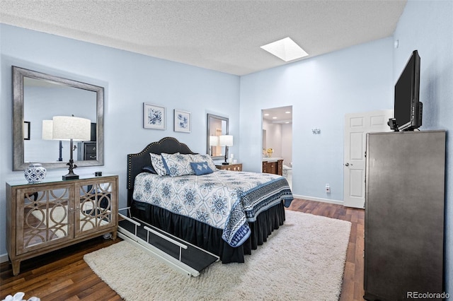 bedroom with a skylight, dark wood-style flooring, lofted ceiling, a textured ceiling, and baseboards