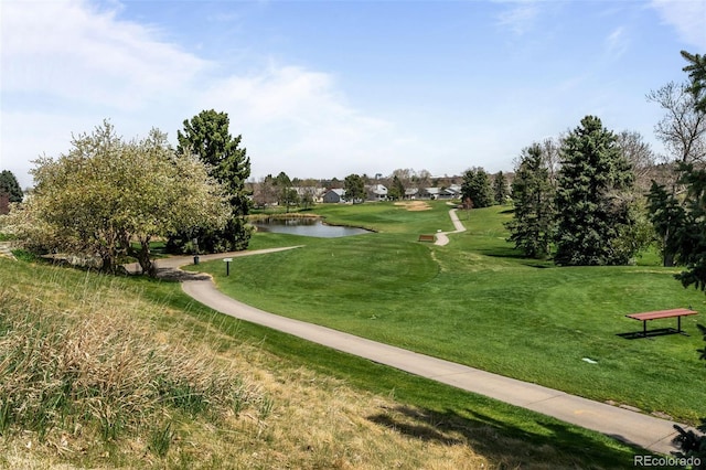 view of home's community featuring a water view, view of golf course, and a yard