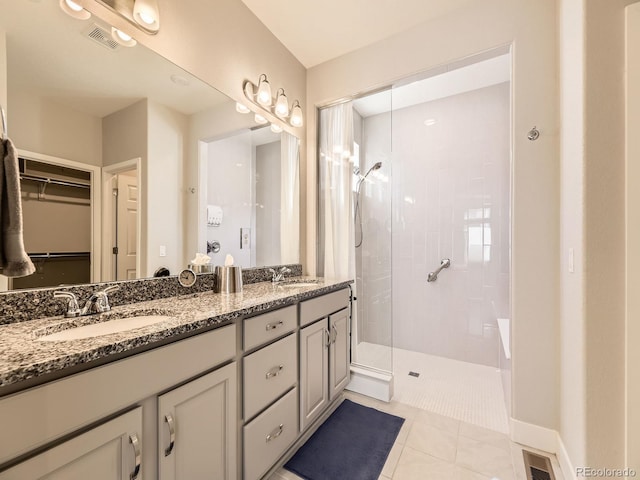 full bathroom with tile patterned flooring, visible vents, a sink, and a walk in shower