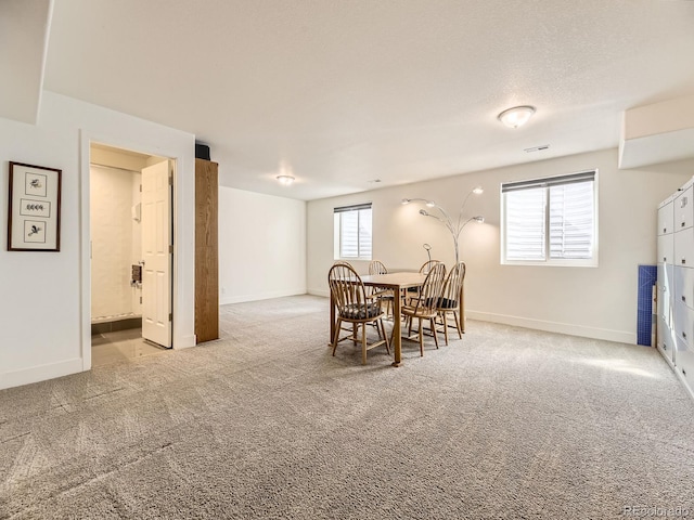 dining space with carpet, visible vents, and baseboards