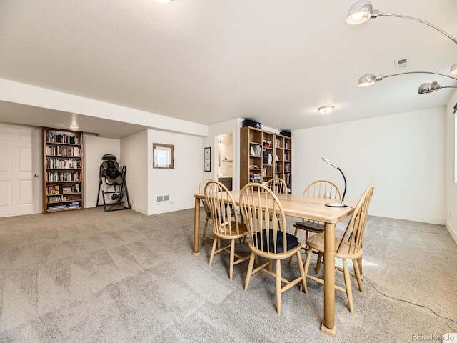 carpeted dining room featuring visible vents and baseboards