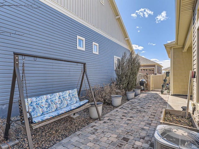 view of patio / terrace featuring grilling area, fence, and central air condition unit