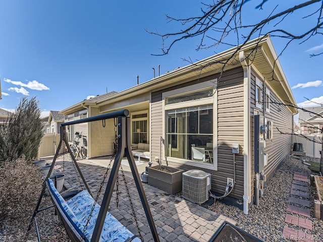 back of property featuring central air condition unit, fence, and a patio