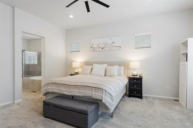 bedroom featuring baseboards, ensuite bathroom, and light colored carpet