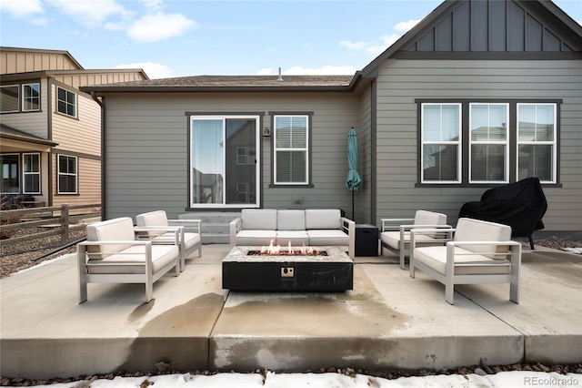 back of property featuring board and batten siding, an outdoor living space with a fire pit, a patio, and fence