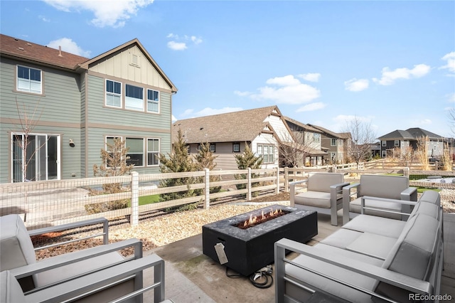 view of patio / terrace featuring a residential view, an outdoor living space with a fire pit, and fence