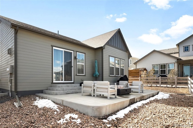 back of house featuring outdoor lounge area, board and batten siding, entry steps, a patio area, and fence