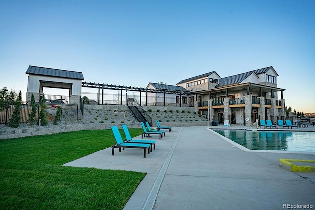 pool featuring a patio, a lawn, and fence