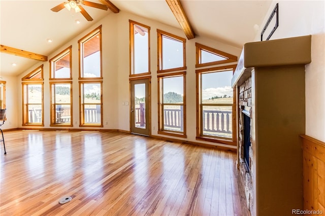 2177 County Road 341, Westcliffe, CO 81252 - unfurnished living room with a fireplace, plenty of natural light, beam ceiling, a ceiling fan, and wood finished floors