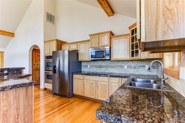 2177 County Road 341, Westcliffe, CO 81252 - kitchen with appliances with stainless steel finishes, a sink, light wood finished floors, arched walkways, and beam ceiling