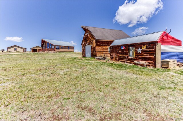 2177 County Road 341, Westcliffe, CO 81252 - view of side of home featuring a garage, a lawn, an outdoor structure, and metal roof