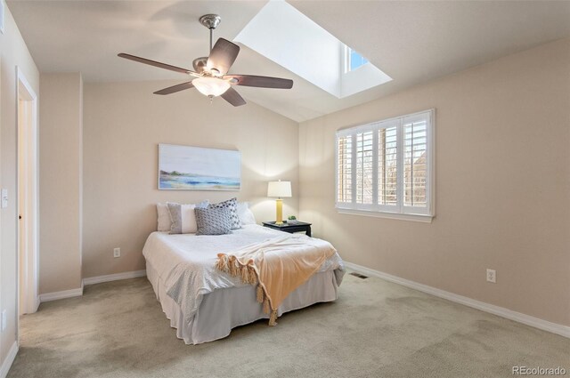 bedroom featuring lofted ceiling with skylight, carpet, ceiling fan, and baseboards