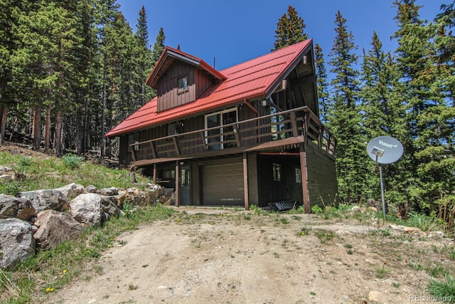 135 Nugget Ln, Alma, CO 80420 - view of front of home with a garage, dirt driveway, board and batten siding, and a wooden deck