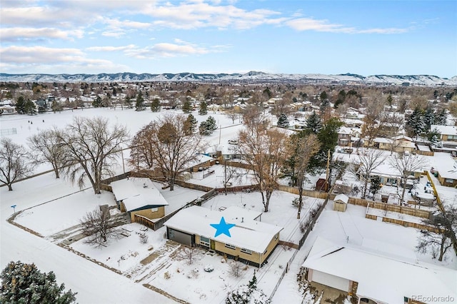 snowy aerial view featuring a residential view and a mountain view