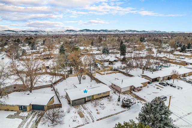 snowy aerial view featuring a residential view and a mountain view