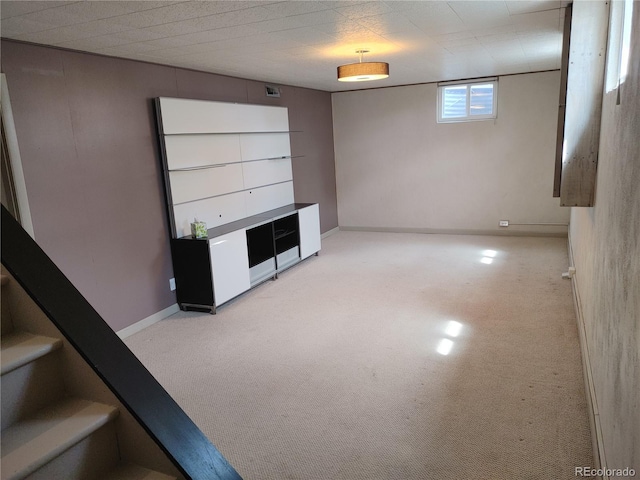 unfurnished living room with baseboards, visible vents, stairway, and light colored carpet