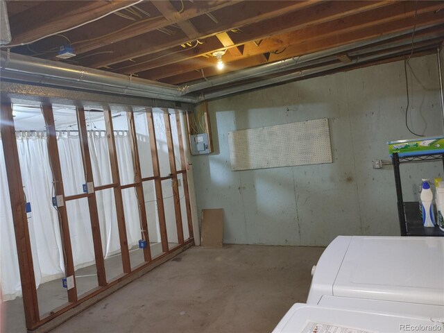 unfinished basement featuring washer / clothes dryer and electric panel