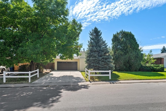 obstructed view of property with a front yard and a garage