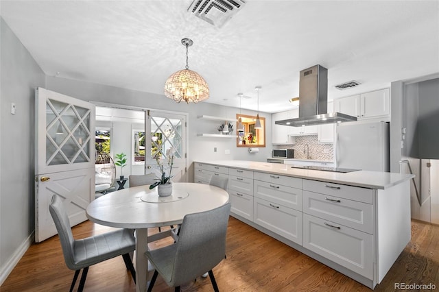 dining space featuring sink, a notable chandelier, and wood-type flooring