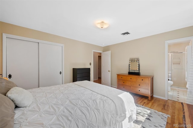 bedroom featuring a closet, connected bathroom, and hardwood / wood-style floors