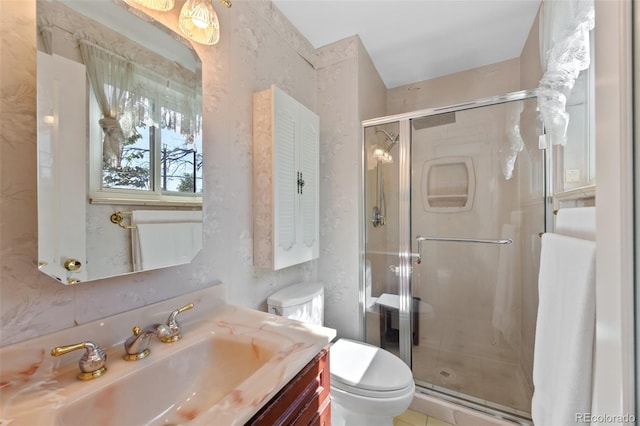 bathroom featuring toilet, a shower with shower door, and vanity