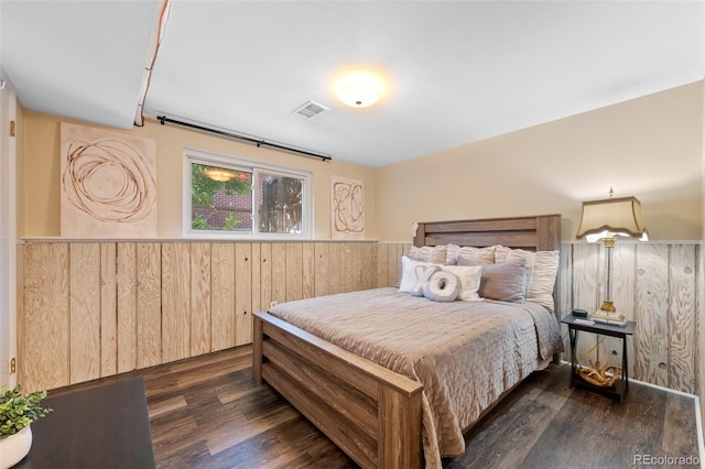 bedroom with wood walls and dark hardwood / wood-style floors