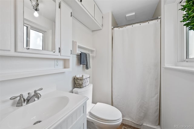 bathroom with vanity, toilet, and a healthy amount of sunlight