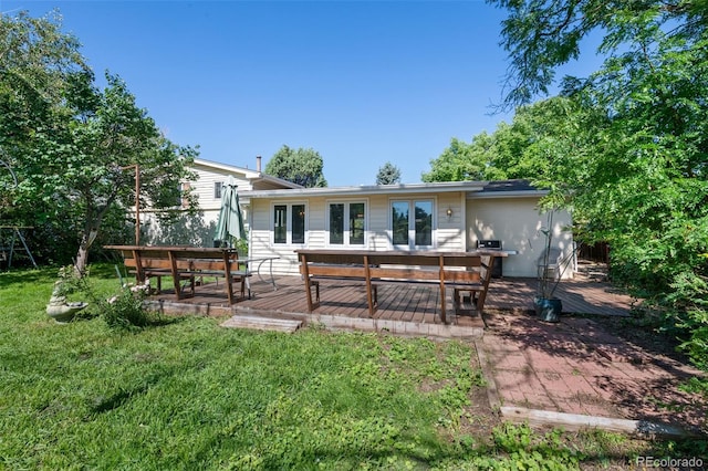 back of house featuring a wooden deck and a lawn