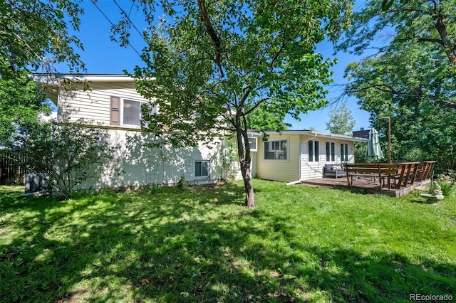 back of house with a wooden deck and a lawn