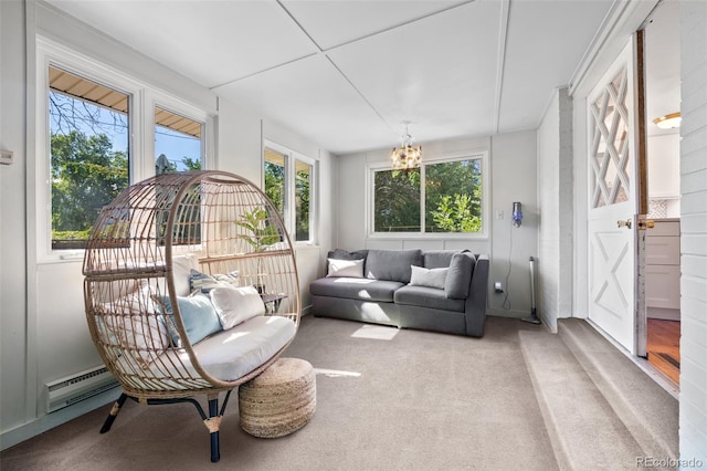 sunroom / solarium with a chandelier, a baseboard heating unit, and a healthy amount of sunlight