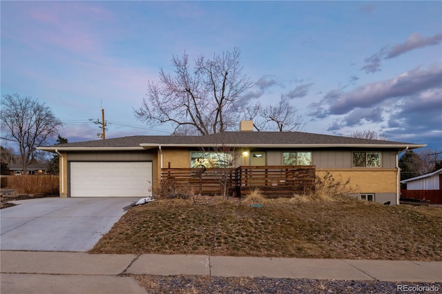 single story home with brick siding, a chimney, an attached garage, fence, and driveway