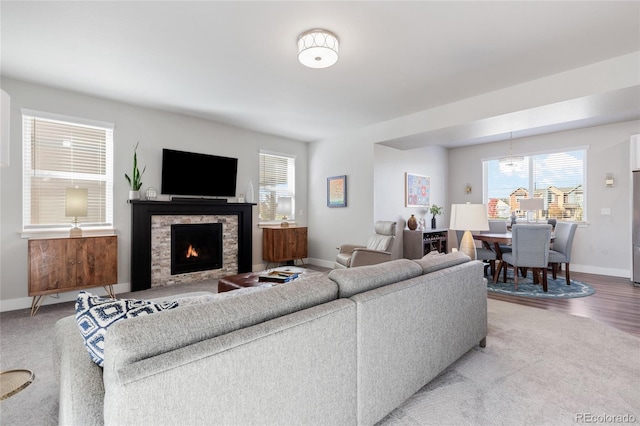 living room with a stone fireplace and carpet