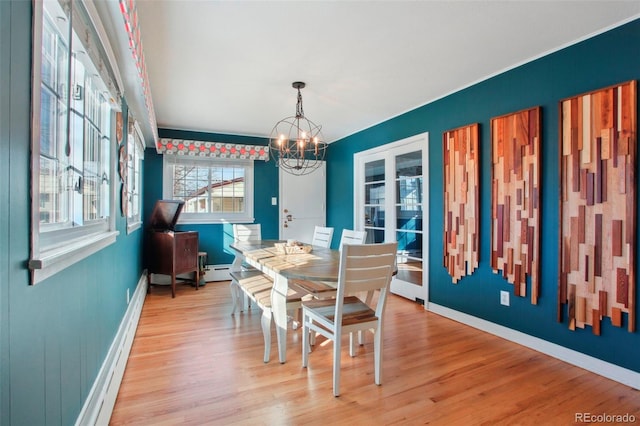 8001 W 57th Ave, Arvada, CO 80002 - dining space featuring a chandelier, light wood-style floors, baseboards, and a baseboard heating unit