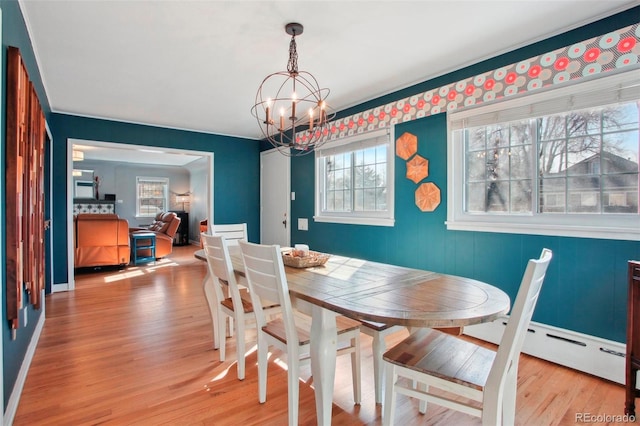 8001 W 57th Ave, Arvada, CO 80002 - dining space featuring a chandelier, light wood-style flooring, and a baseboard heating unit