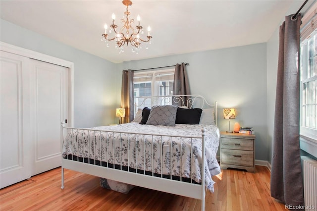 8001 W 57th Ave, Arvada, CO 80002 - bedroom featuring wood finished floors, a chandelier, radiator heating unit, a closet, and baseboards