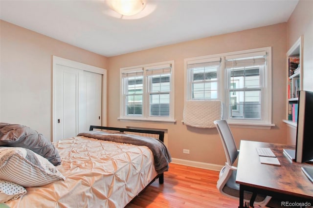 8001 W 57th Ave, Arvada, CO 80002 - bedroom featuring wood finished floors, a closet, baseboards, and radiator