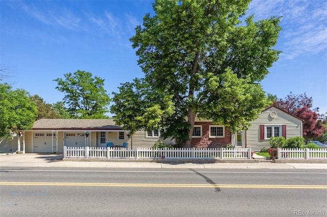8001 W 57th Ave, Arvada, CO 80002 - view of front of property with an attached garage, a fenced front yard, and driveway