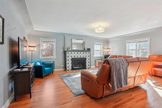 8001 W 57th Ave, Arvada, CO 80002 - living room with healthy amount of natural light, wood finished floors, a fireplace, and baseboards