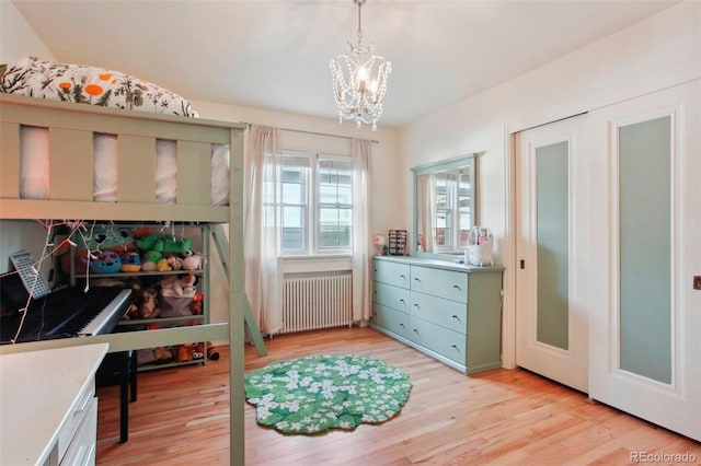 8001 W 57th Ave, Arvada, CO 80002 - bedroom with radiator heating unit, a chandelier, and light wood-type flooring