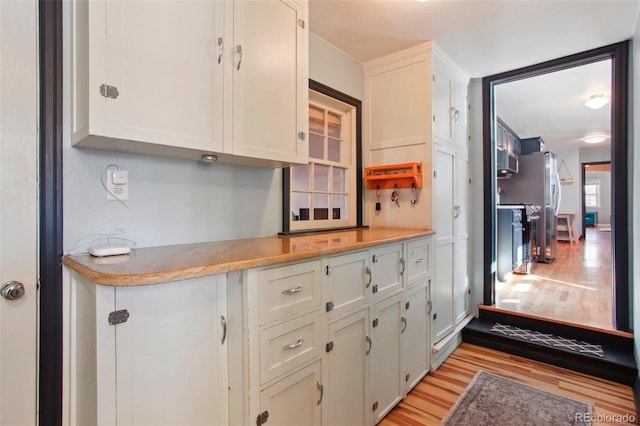 8001 W 57th Ave, Arvada, CO 80002 - kitchen featuring light wood-type flooring, appliances with stainless steel finishes, light countertops, and white cabinetry