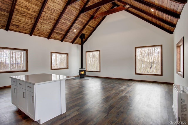 interior space with a wood stove, dark wood-type flooring, and wood ceiling