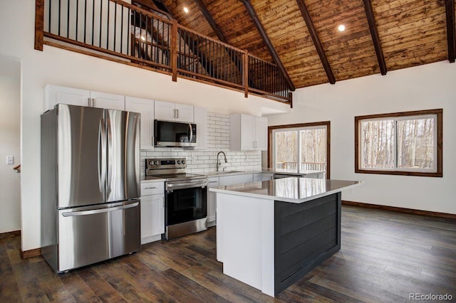 kitchen with stainless steel appliances, tasteful backsplash, dark wood-type flooring, white cabinetry, and wooden ceiling