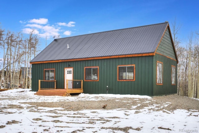 snow covered property featuring metal roof